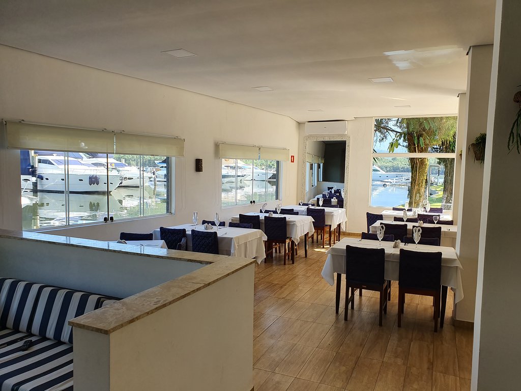 Salão do restaurante com vista para as embarcações